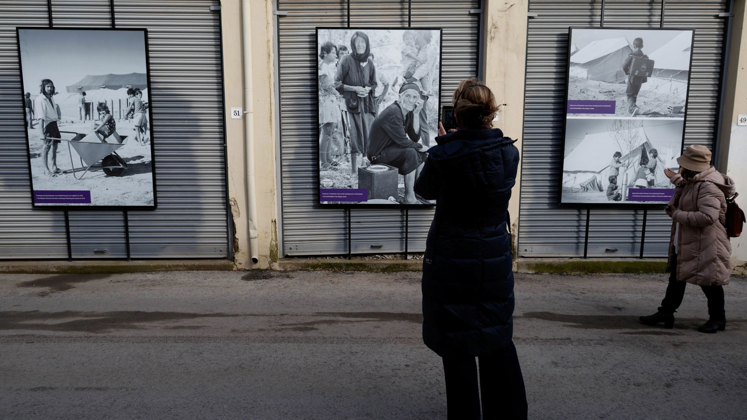 Woman looking at photo panels in street