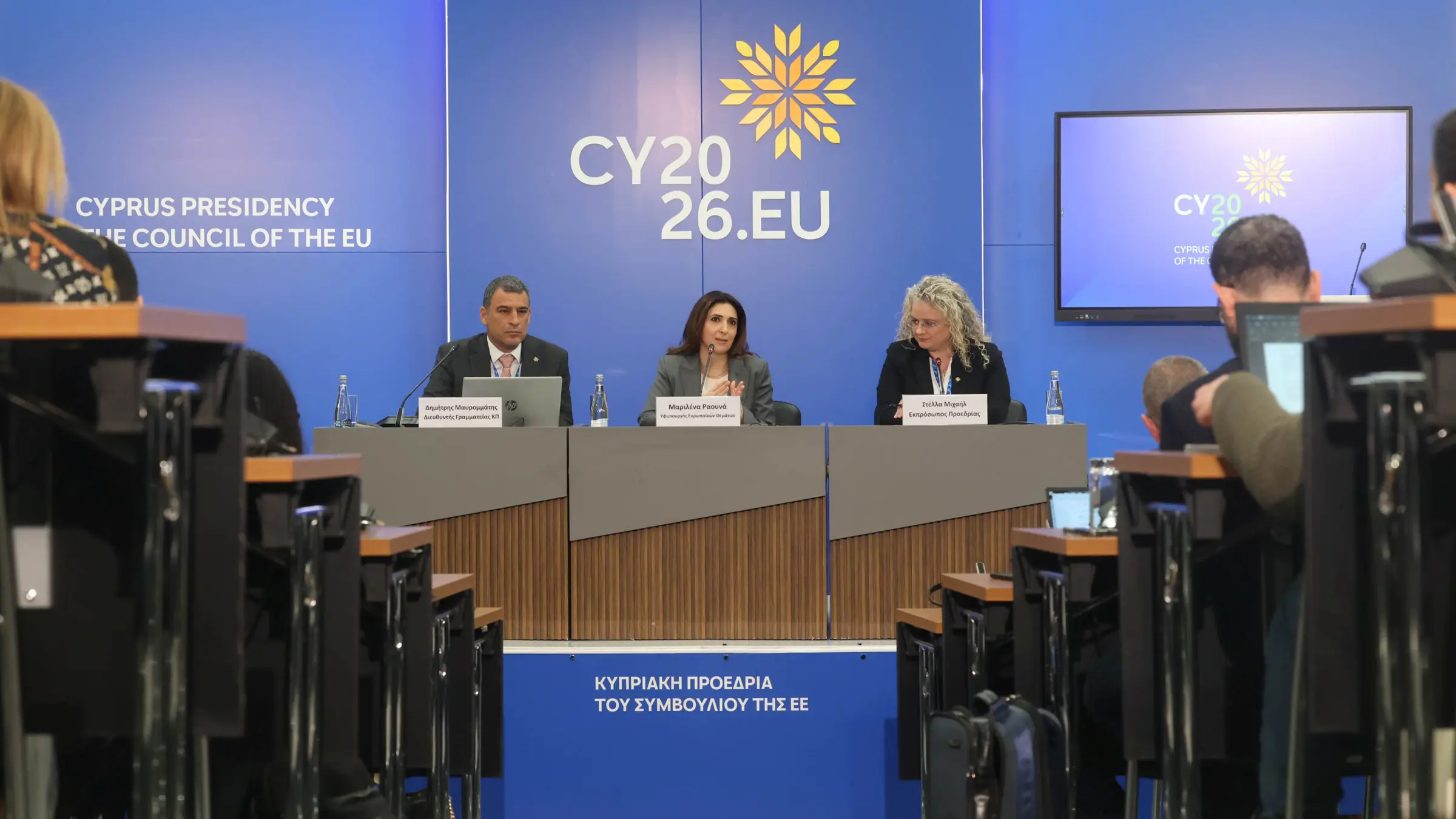 three people sitting on podium