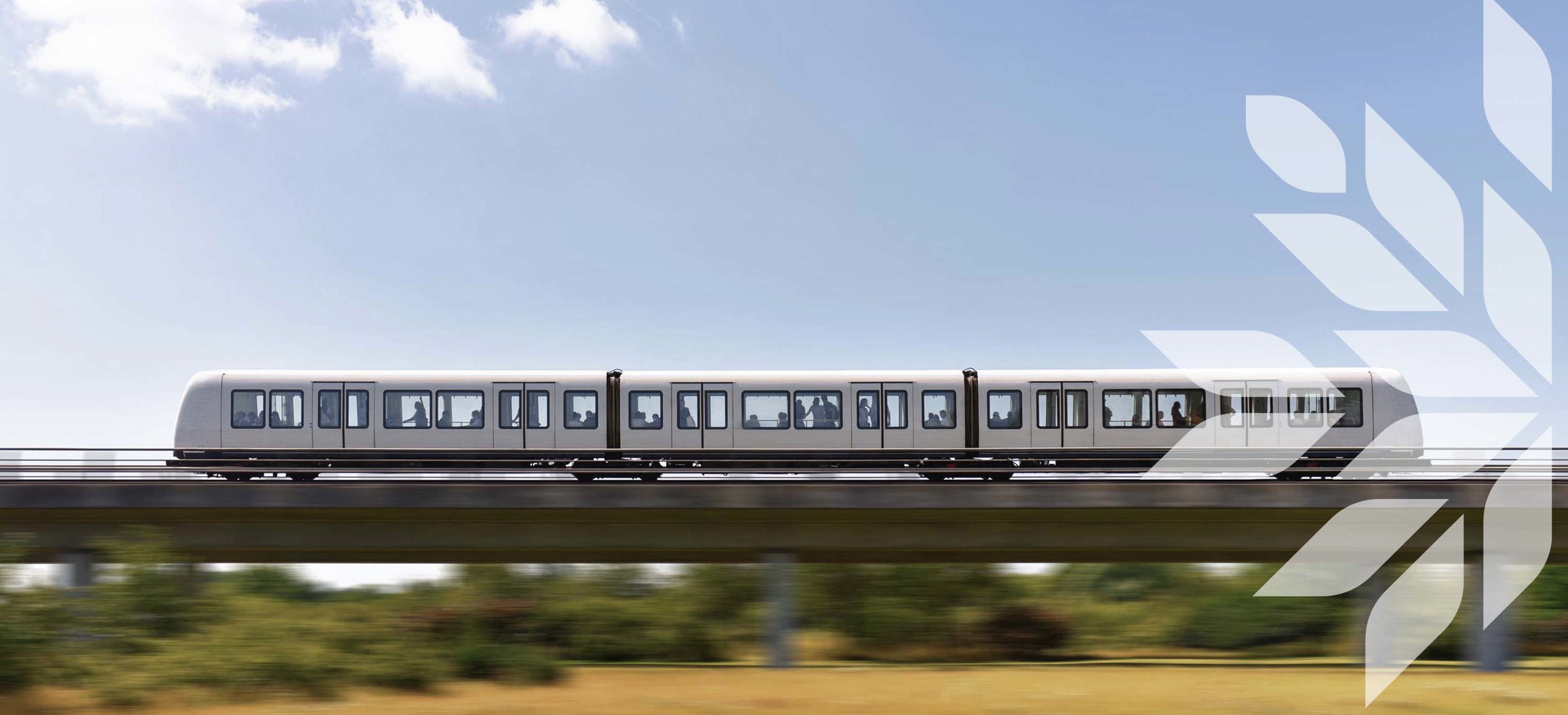 A metro runs on an elevated railway over wild landscape 