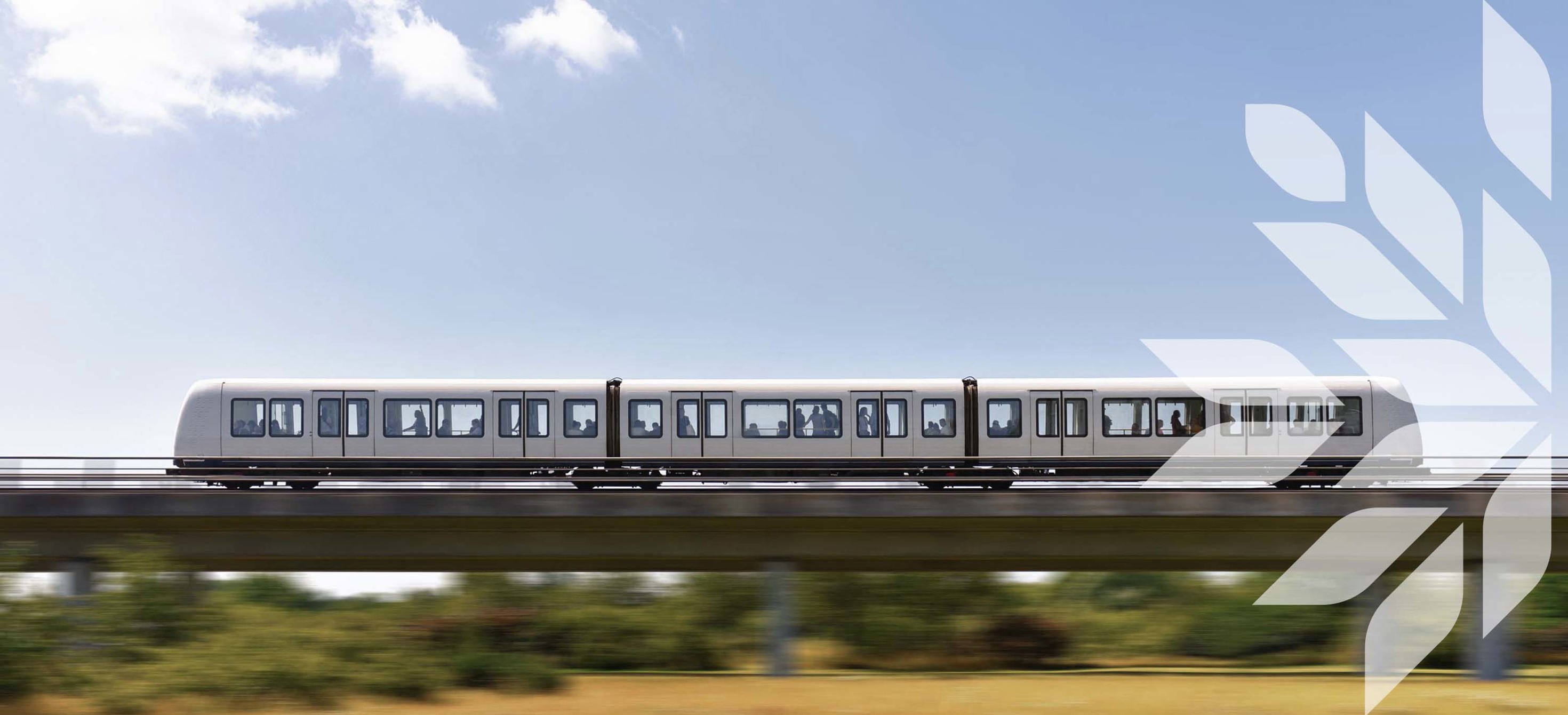 A metro runs on an elevated railway over wild landscape 