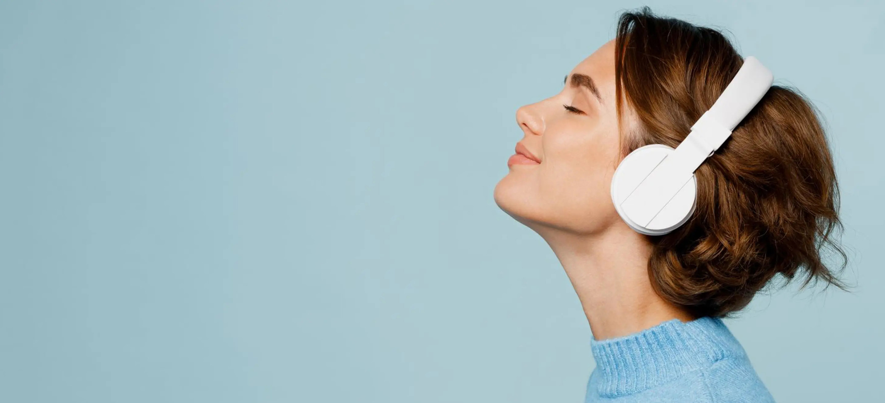 Young women wearing headphones listening to music with eyes closed
